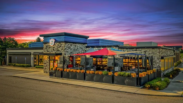 The Clarkston restaurant at sunset, with the patio umbrellas up and the windows lit