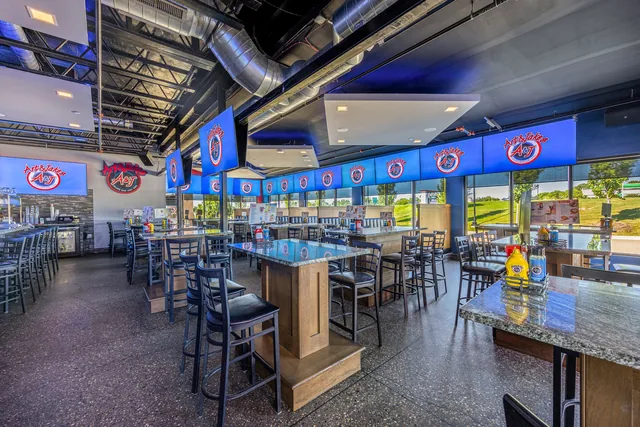 The Clarkston dining room, high-top tables along the windows with the games on
