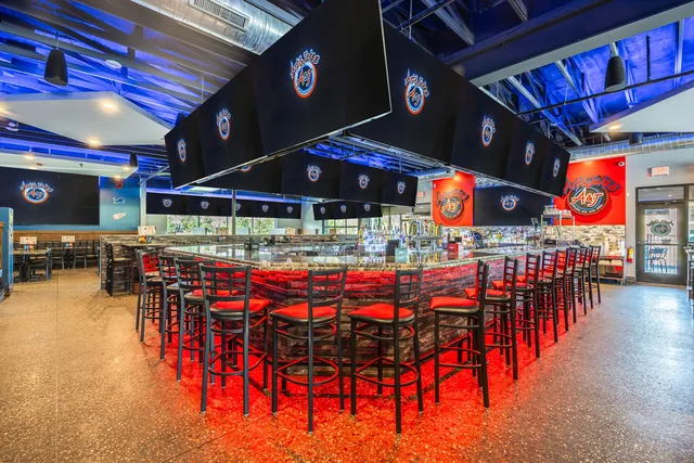 The Northville dining room in red light, high tops set for a game