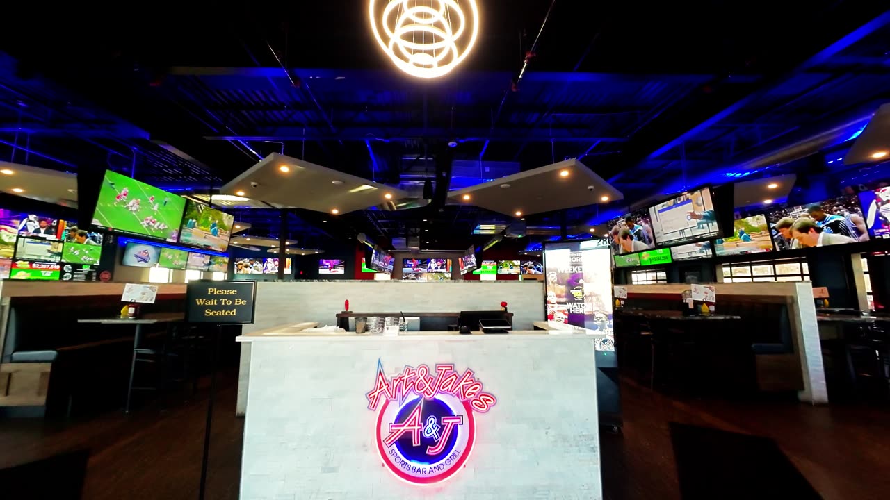 Inside Art & Jake's — the bar, walls of TVs, and game-day energy